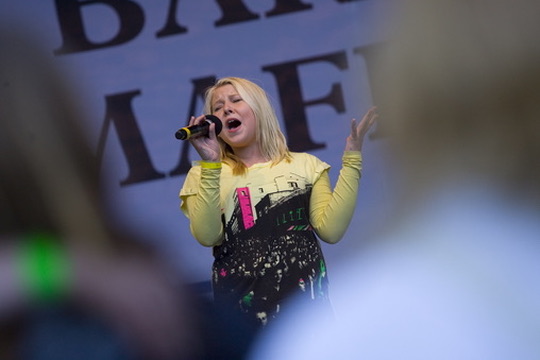 Blond artist synger på scene